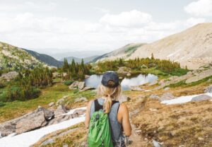 Woman standing in front of alpine lake